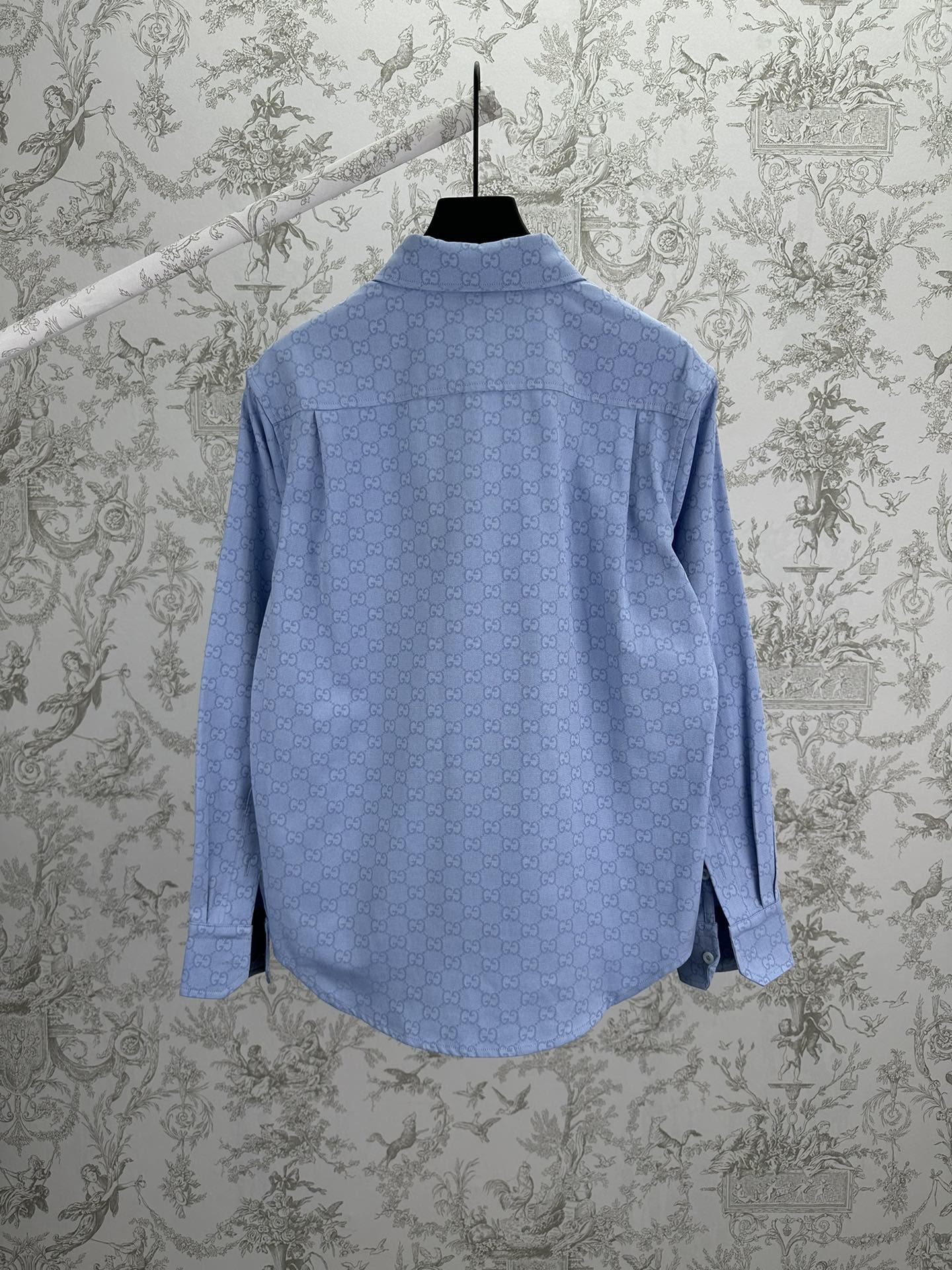 Light blue Gucci button-up shirt with GG monogram, back view on hanger