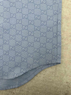 Light blue Gucci shirt hem with GG monogram texture and visible stitching