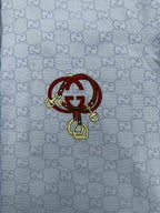 Light blue Gucci shirt front with GG pattern and red crest patch