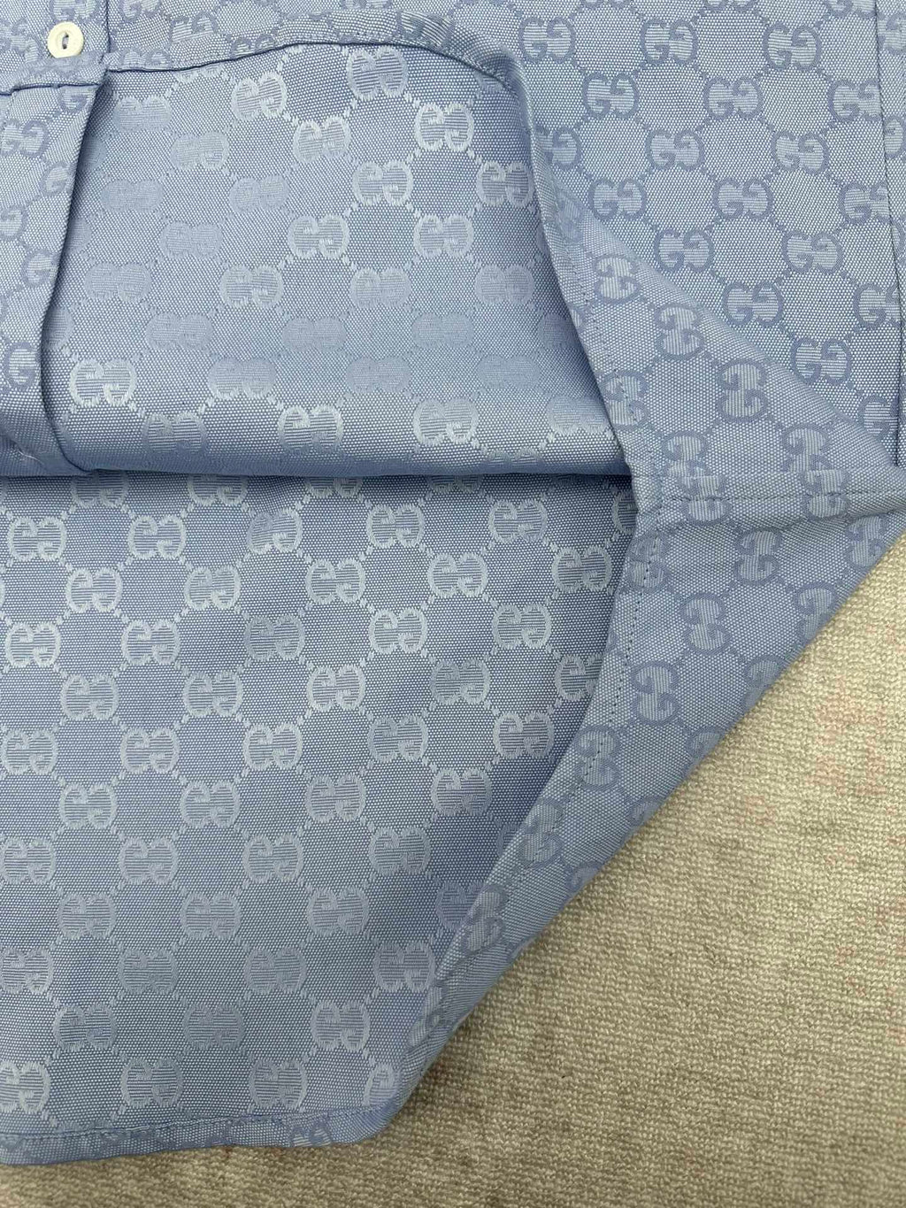 Light blue Gucci button-up shirt hem and inner placket with GG monogram pattern