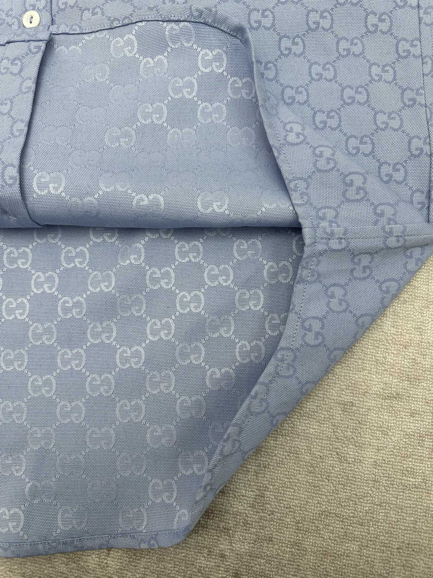 Light blue Gucci button-up shirt hem and inner placket with GG monogram pattern