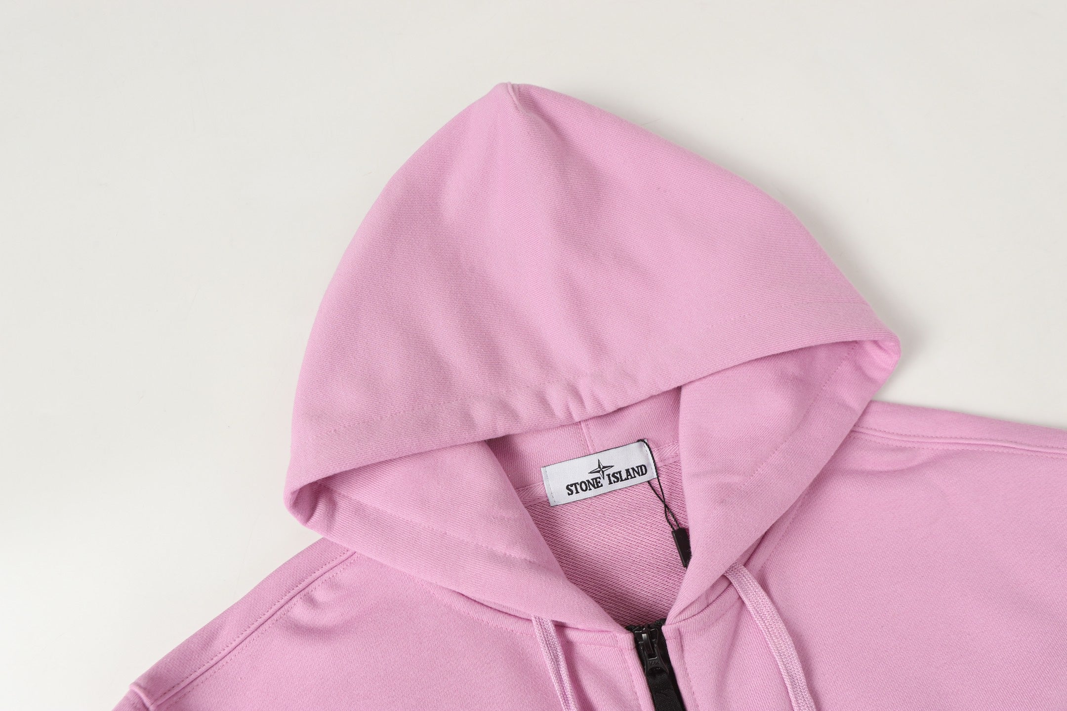 Stone Island hoodie hood with interior neck label, light pink fabric.