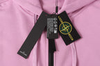 Stone Island hoodie collar with black tags and yellow logo emblem, light pink.