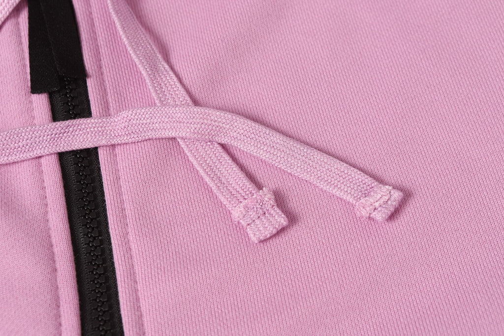 Stone Island hoodie drawstring with black zipper tape on light pink fabric.