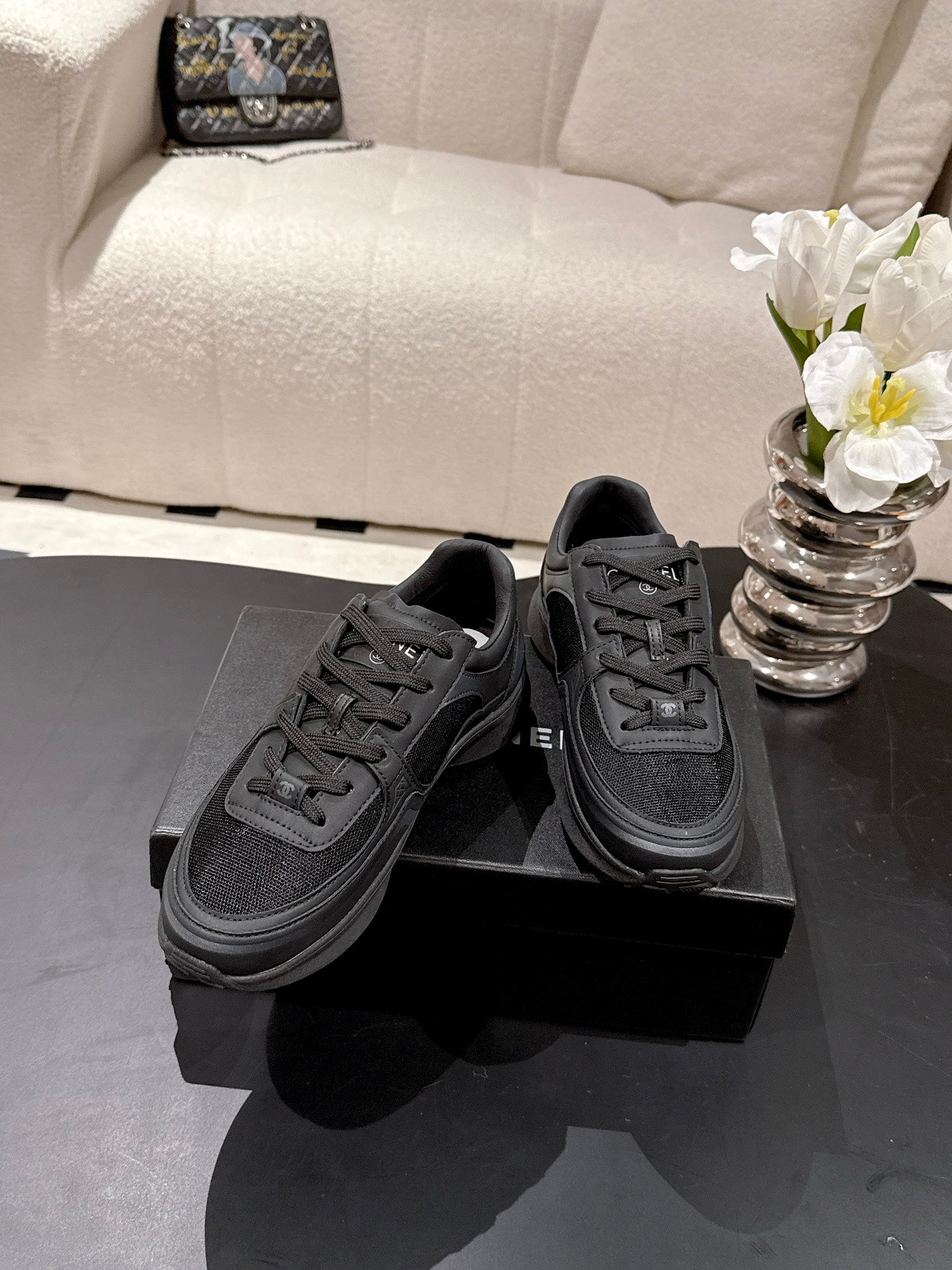 Pair of black lace-up low-top sneakers with Chanel logo, padded collar, rubber sole