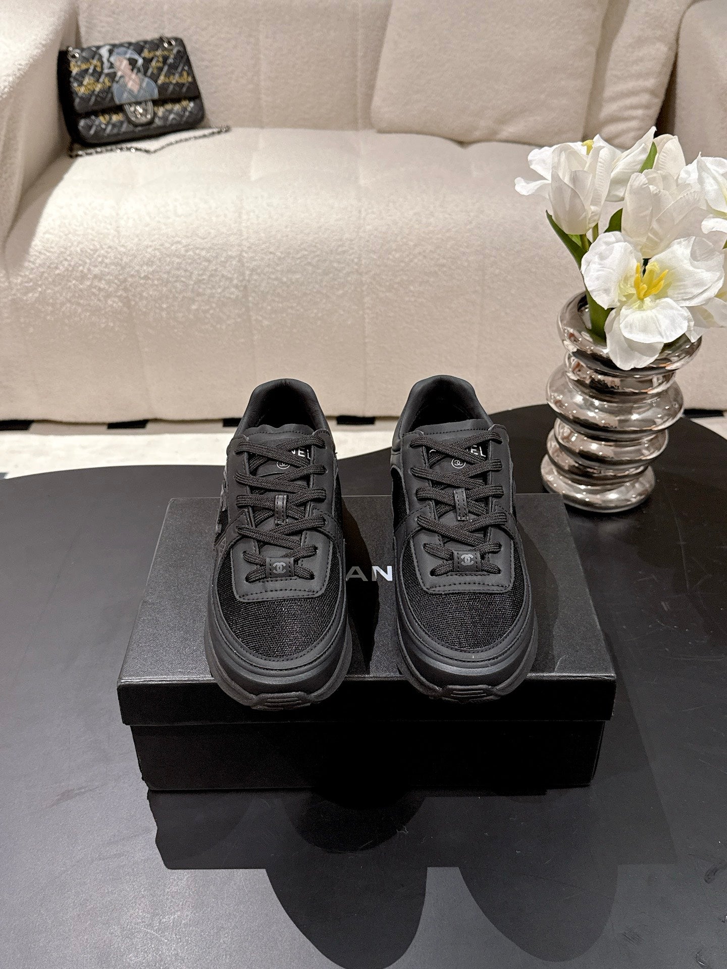 Black unisex low-top sneakers with Chanel logo, lace-up front, rubber sole