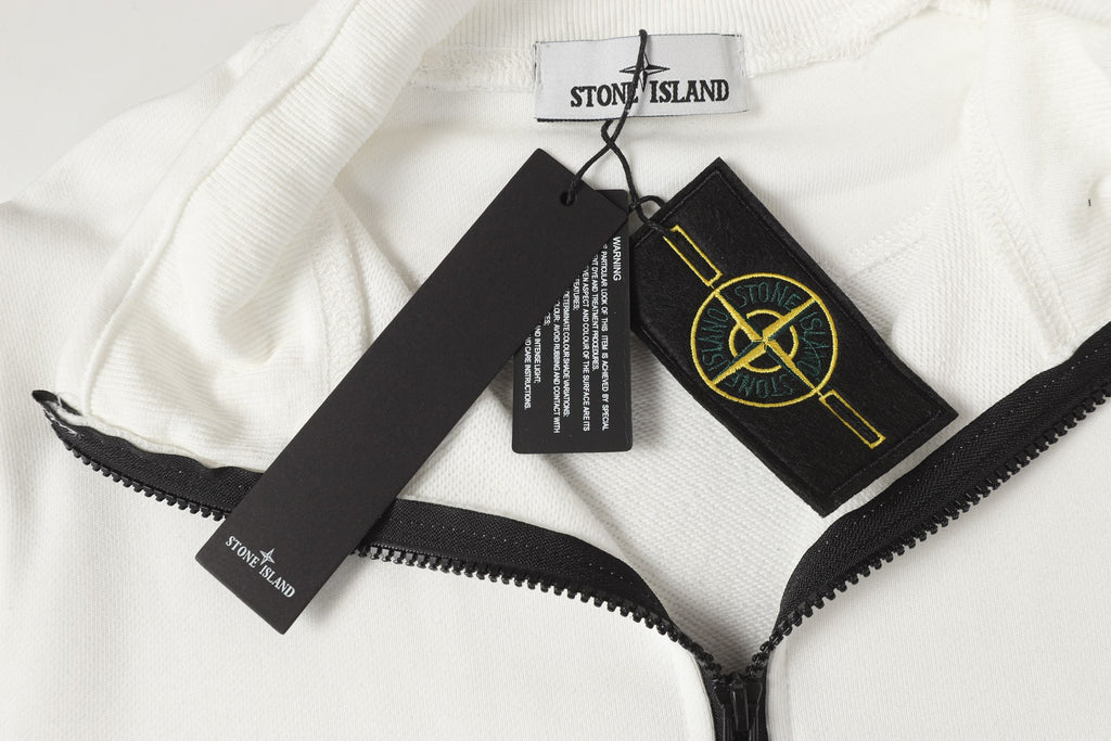 Stone Island quarter-zip fabric close-up with black zipper and branded tags