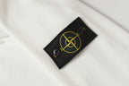 Stone Island sleeve logo patch on white sweatshirt with yellow emblem detail