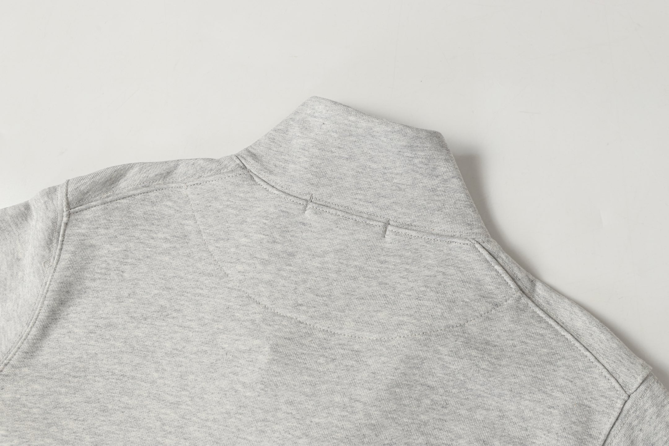 Light gray sweatshirt with high mock neck and small seam detail