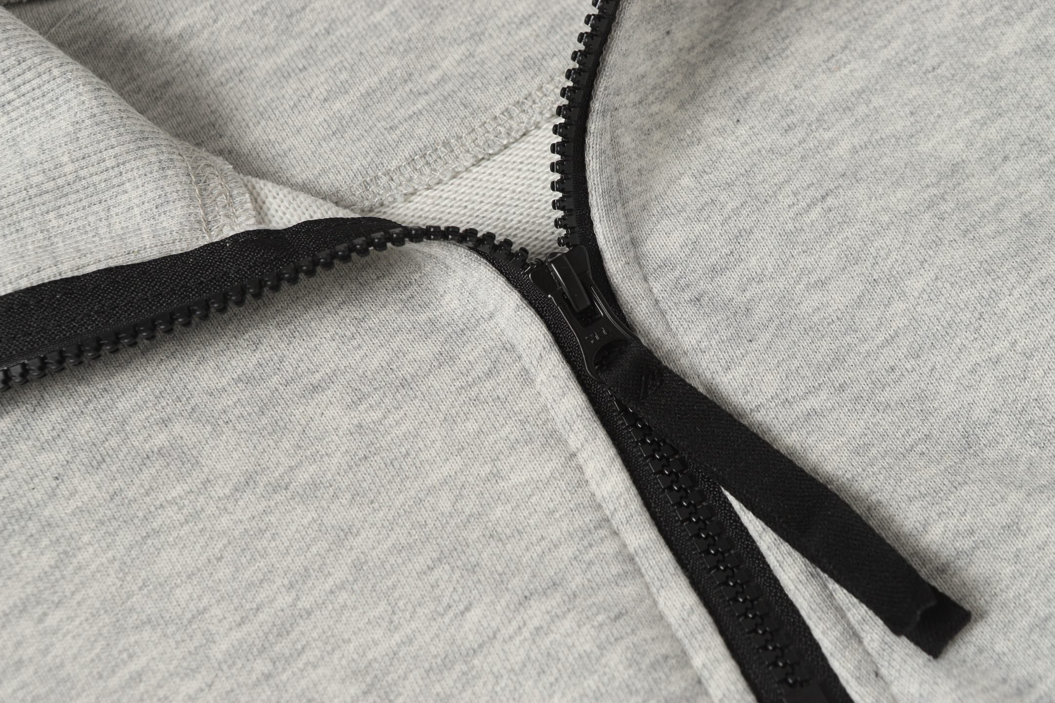 Light gray zip sweatshirt with black zipper and textured edge stitching