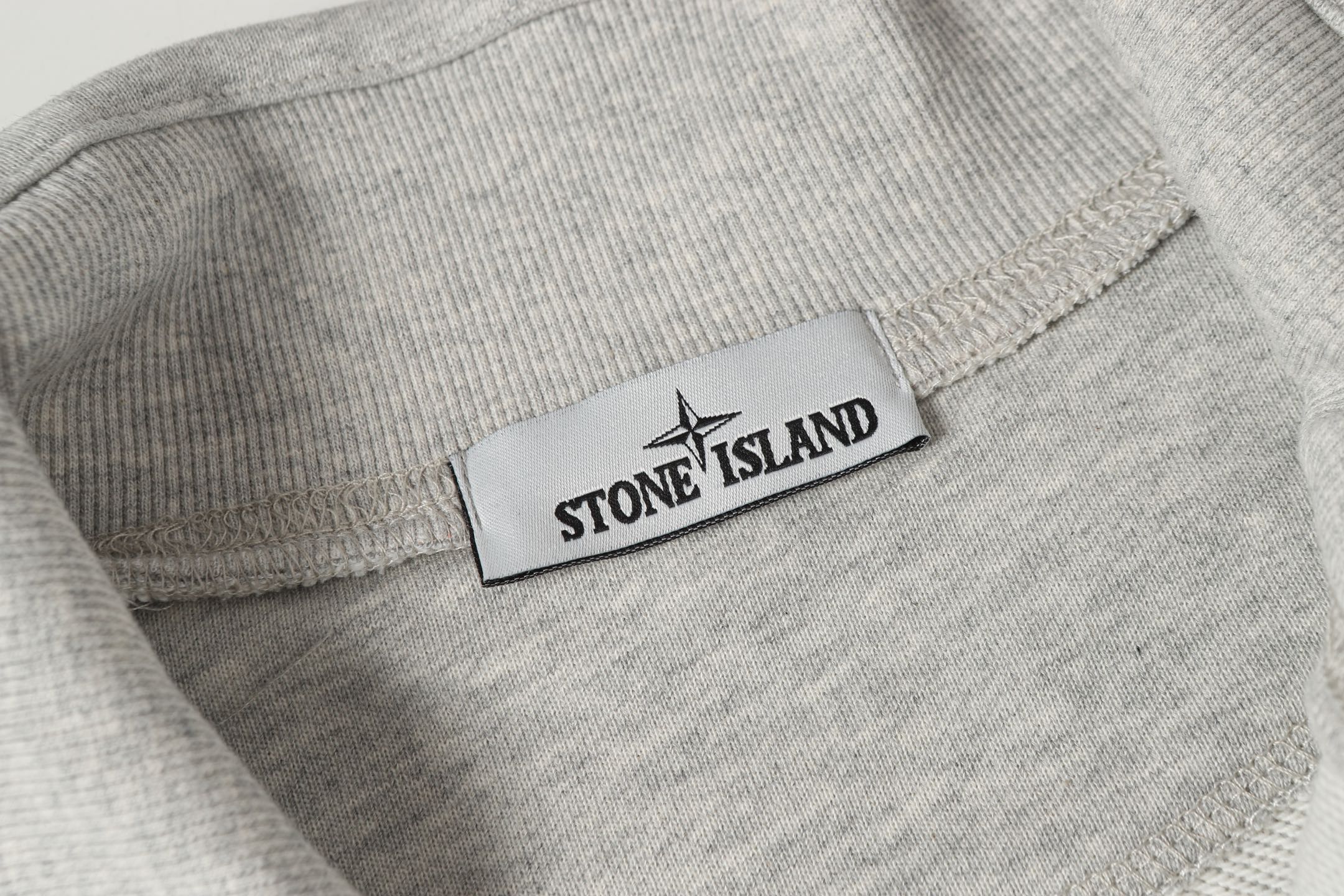 Light gray sweatshirt with ribbed collar and Stone Island logo patch