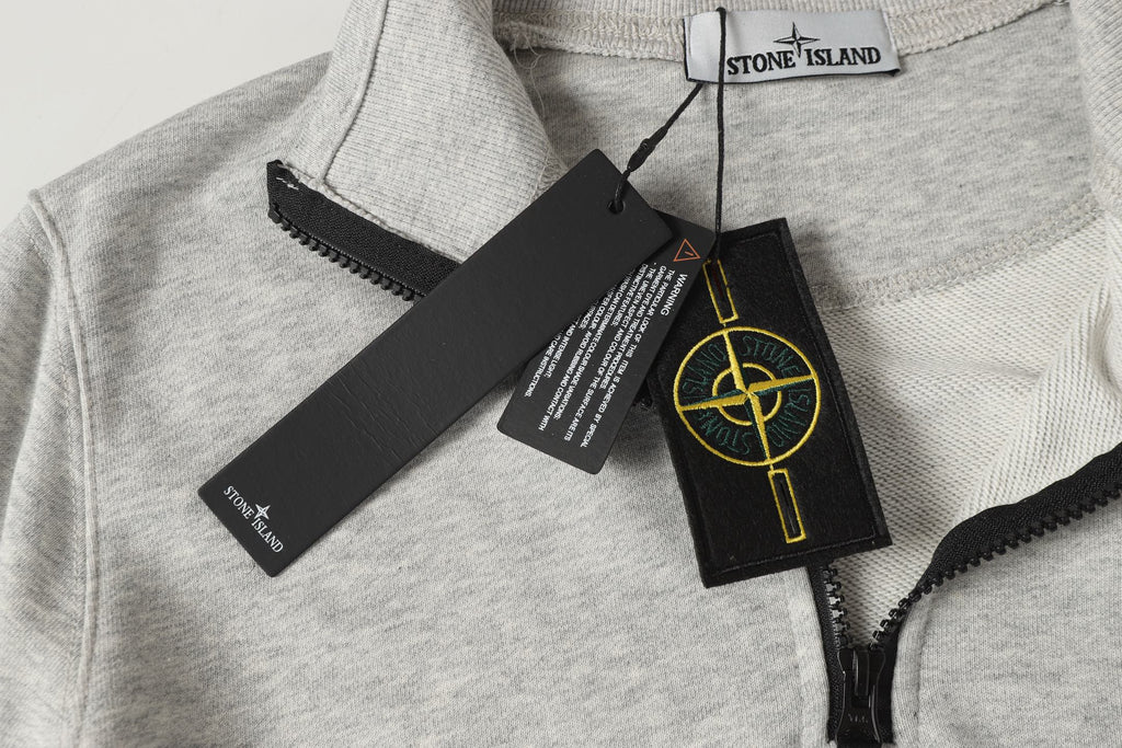 Light gray zip sweatshirt collar with Stone Island label and hanging tags