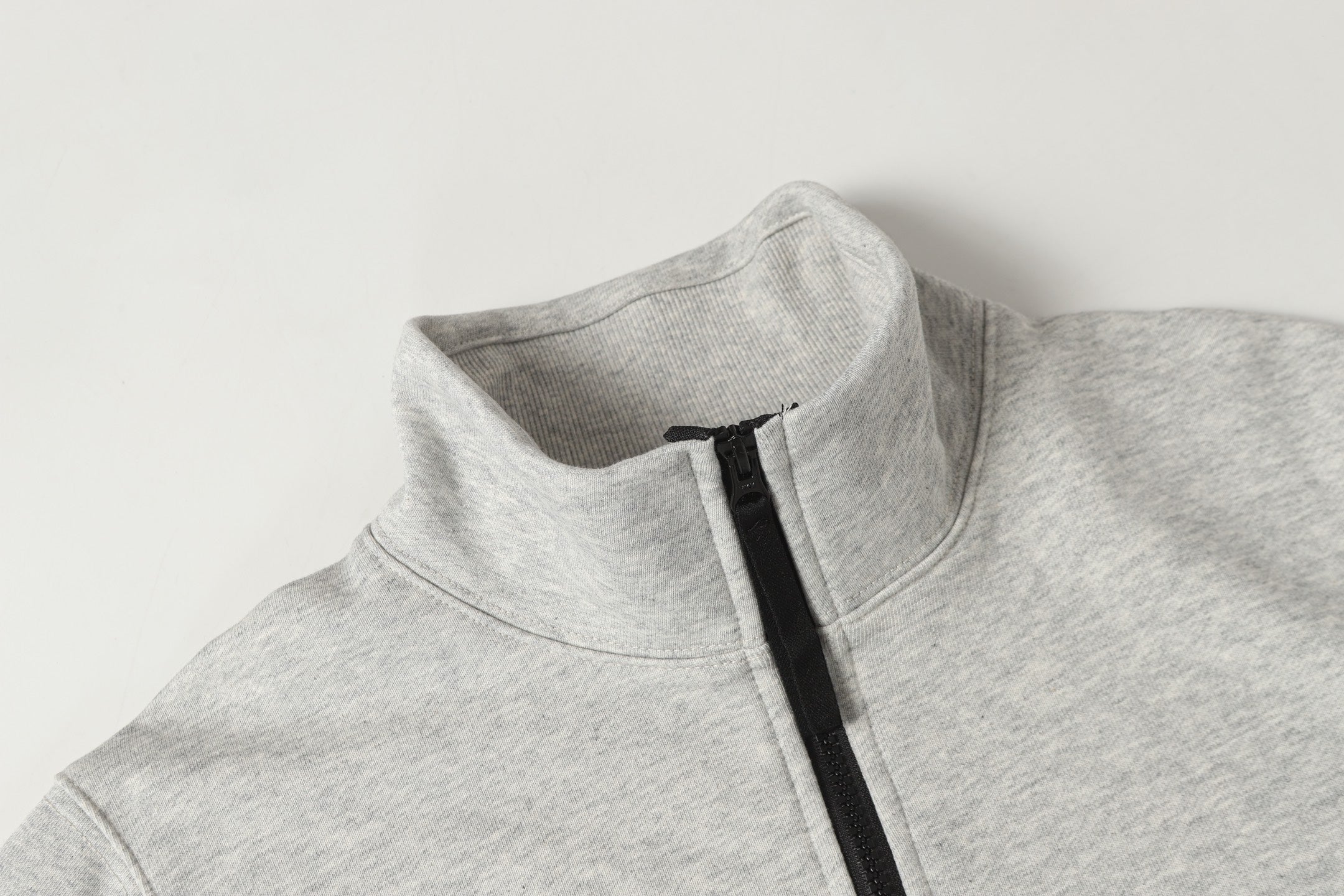 Light gray zip sweatshirt neckline with black zipper track