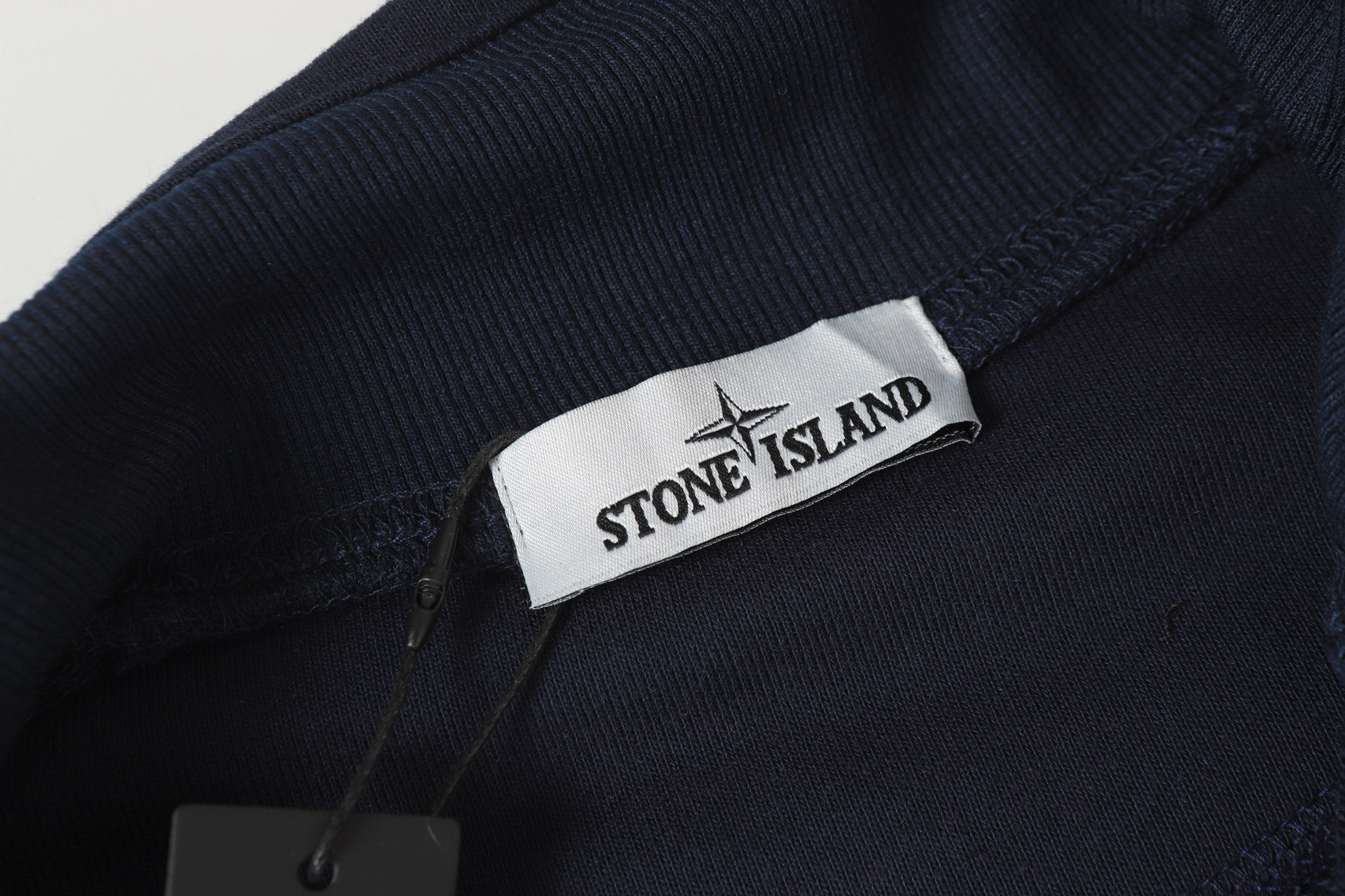 Stone Island logo patch on dark sweatshirt chest