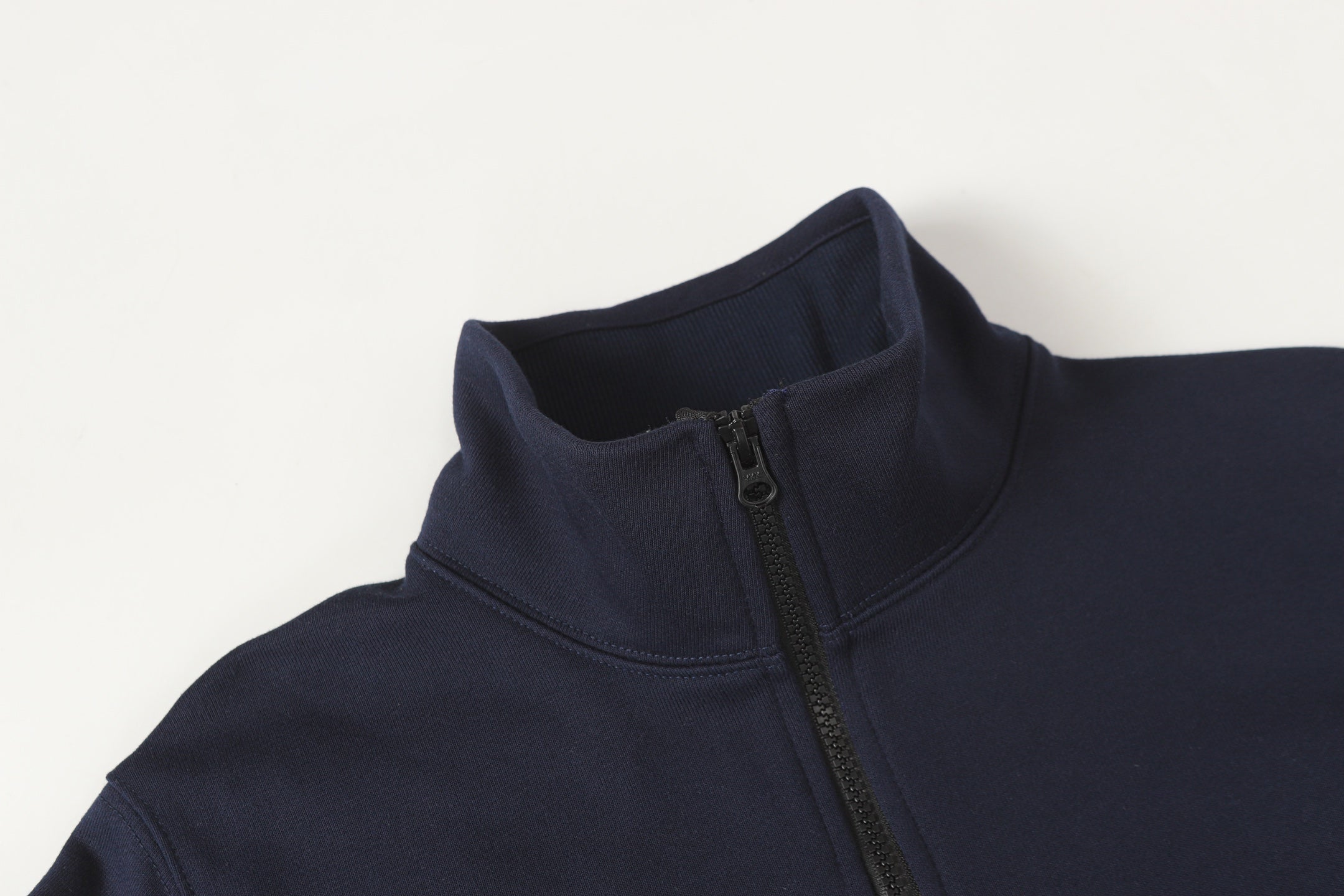 Dark navy quarter-zip sweatshirt collar with half zipper and stand neckline.