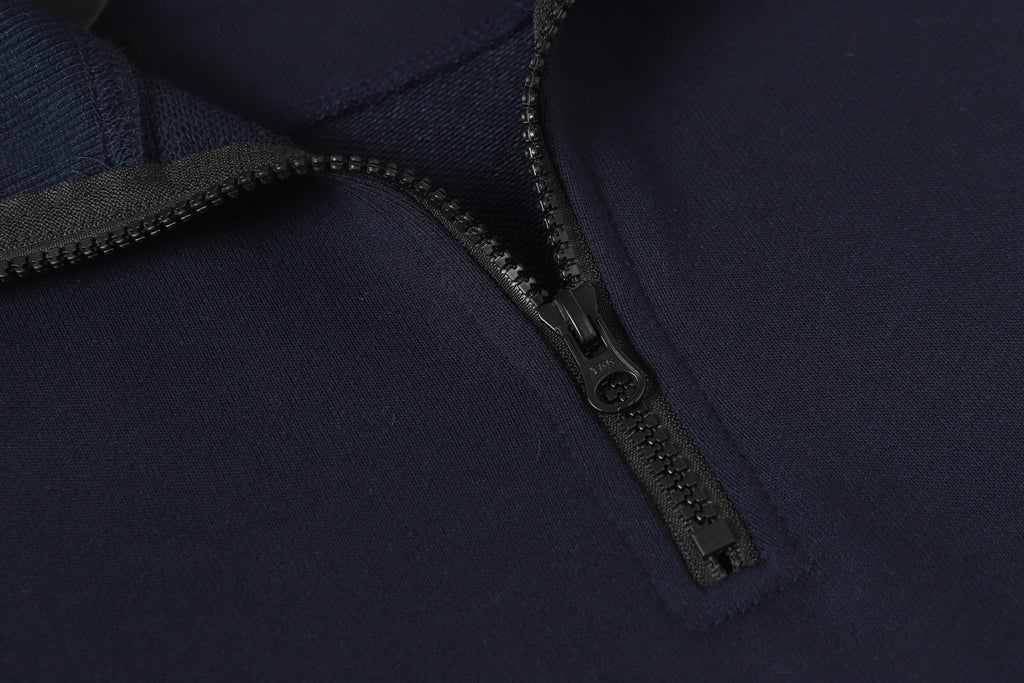 Navy quarter-zip sweatshirt with metal zipper and textured placket.