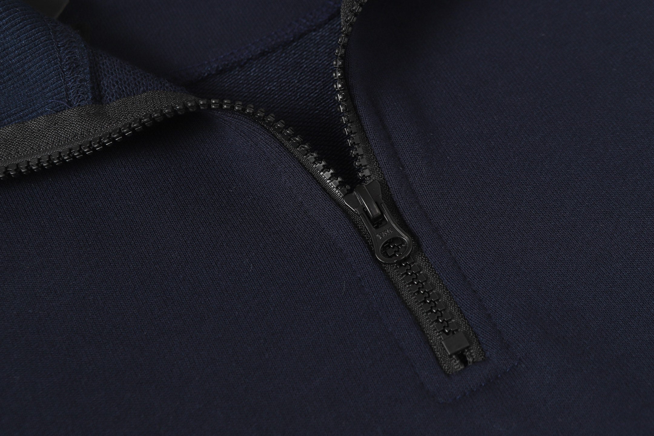 Navy quarter-zip sweatshirt with metal zipper and textured placket.