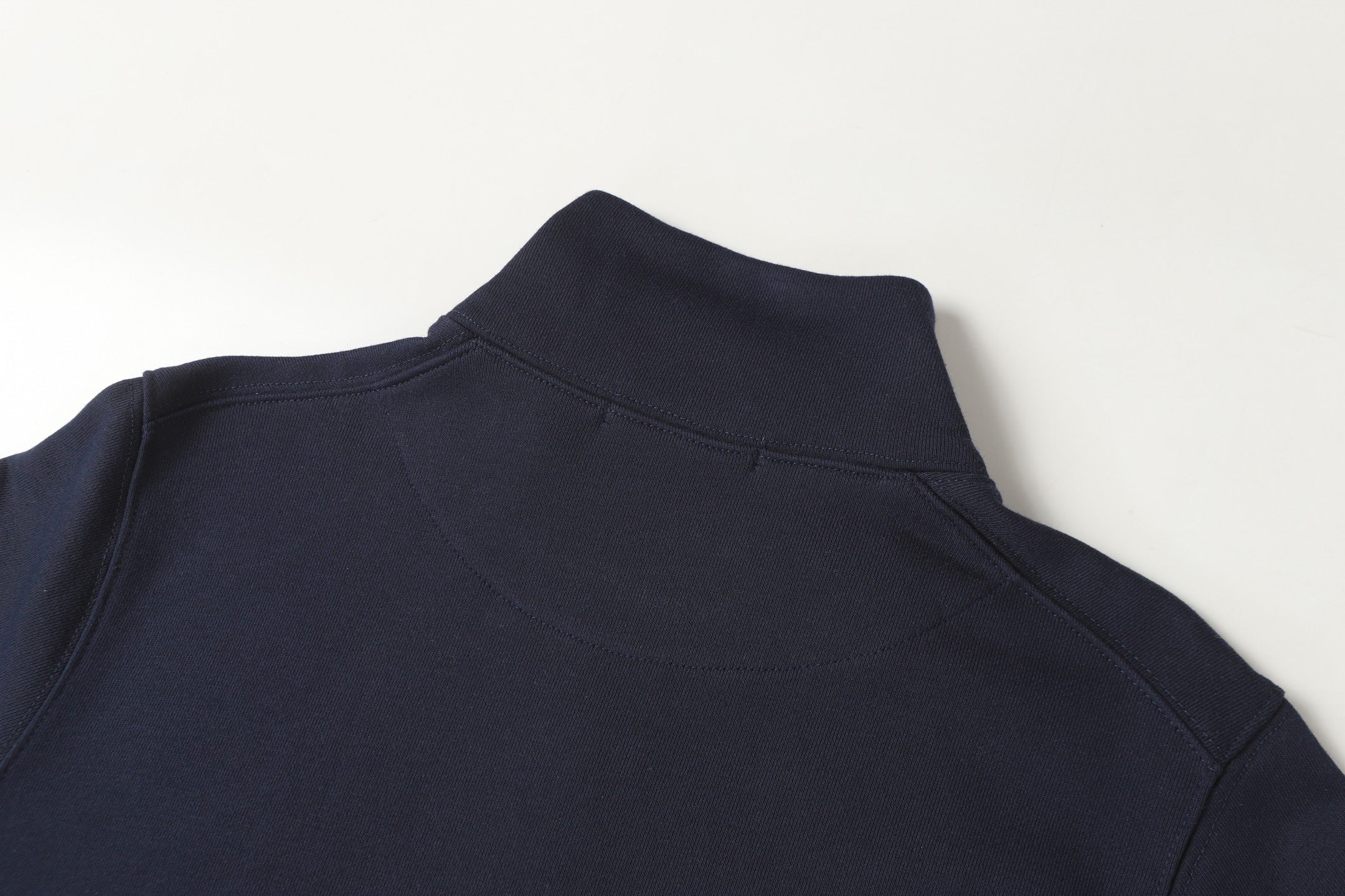 Navy quarter-zip sweatshirt shoulder and upper back section.