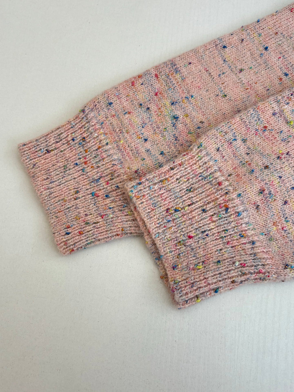 Pink speckled knit cardigan sweater sleeve and side hem with ribbed cuffs
