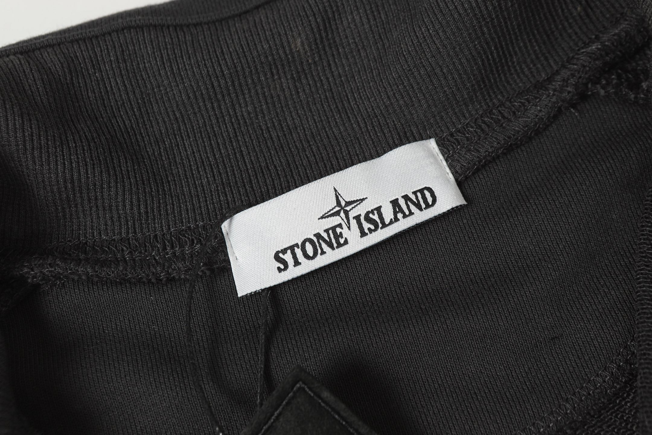 Stone Island dark trousers with logo label and waistband patch