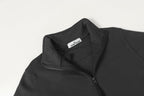 Black half-zip sweatshirt neckline with inner collar label, shoulder close-up