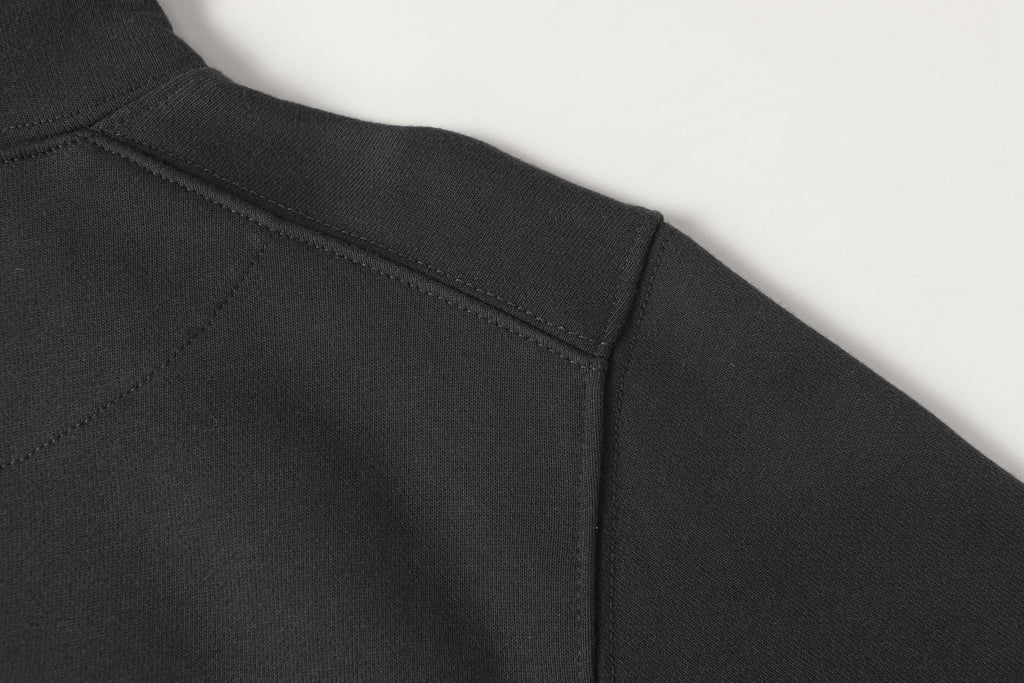 Black half-zip sweatshirt waistband and side seam detail