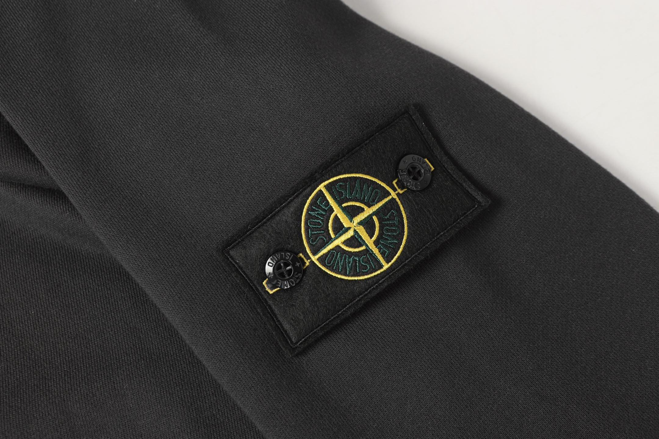 Stone Island dark trousers with emblem patch and metal eyelets