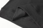Black ribbed waistband detail on half-zip sweatshirt, folded close-up