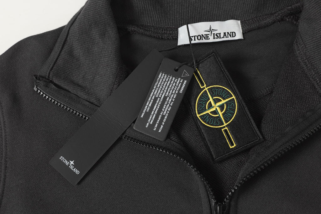 Black half-zip sweatshirt close-up with zipper pull and interior brand label