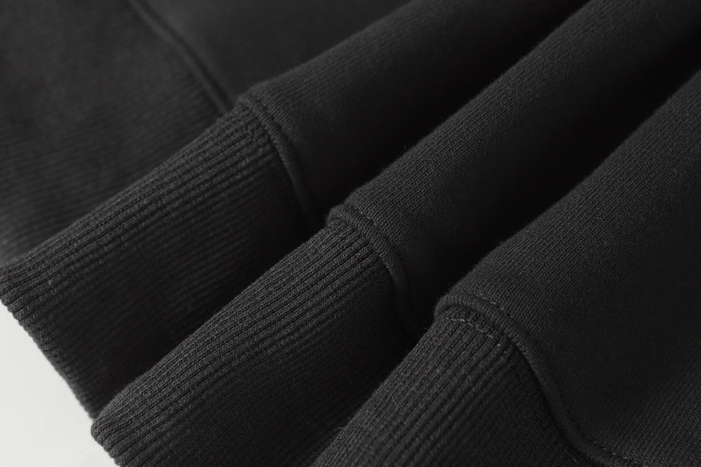 Black ribbed knit cuffs on half-zip sweatshirt sleeves