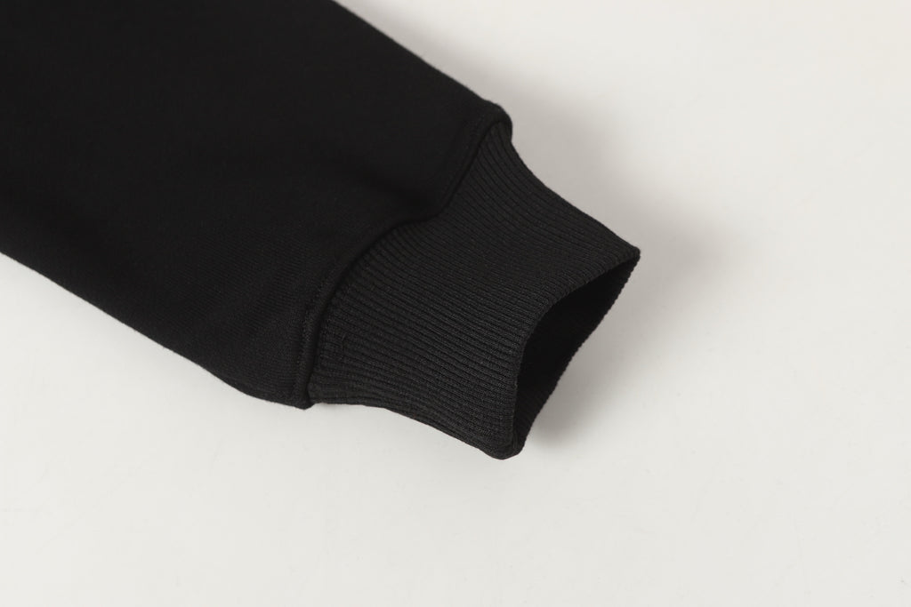 Black ribbed sleeve cuff on quarter-zip sweatshirt
