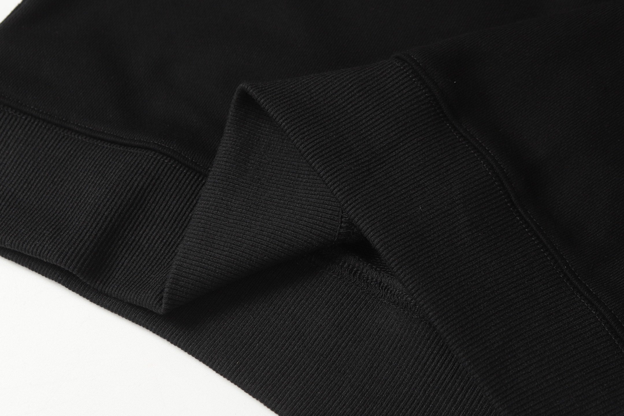 Black ribbed knit cuff and hem band on quarter-zip sweatshirt