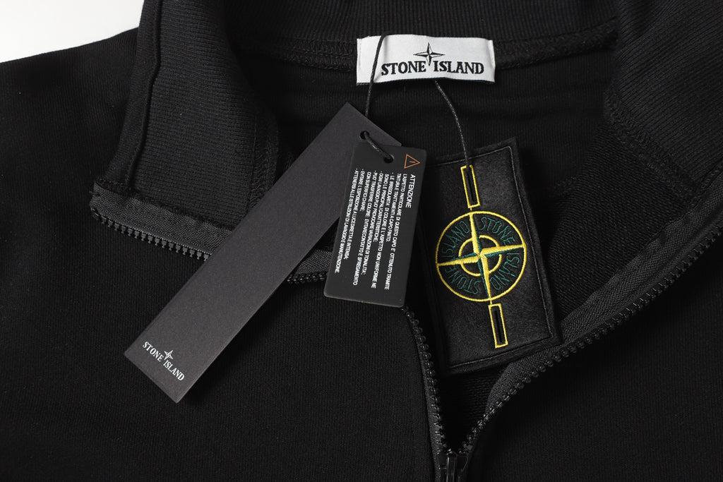 Black quarter-zip top with metal zipper pull, neck label, and care tag