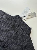 Dark Dior monogram sleeveless vest with stand collar and logo tag near neckline.