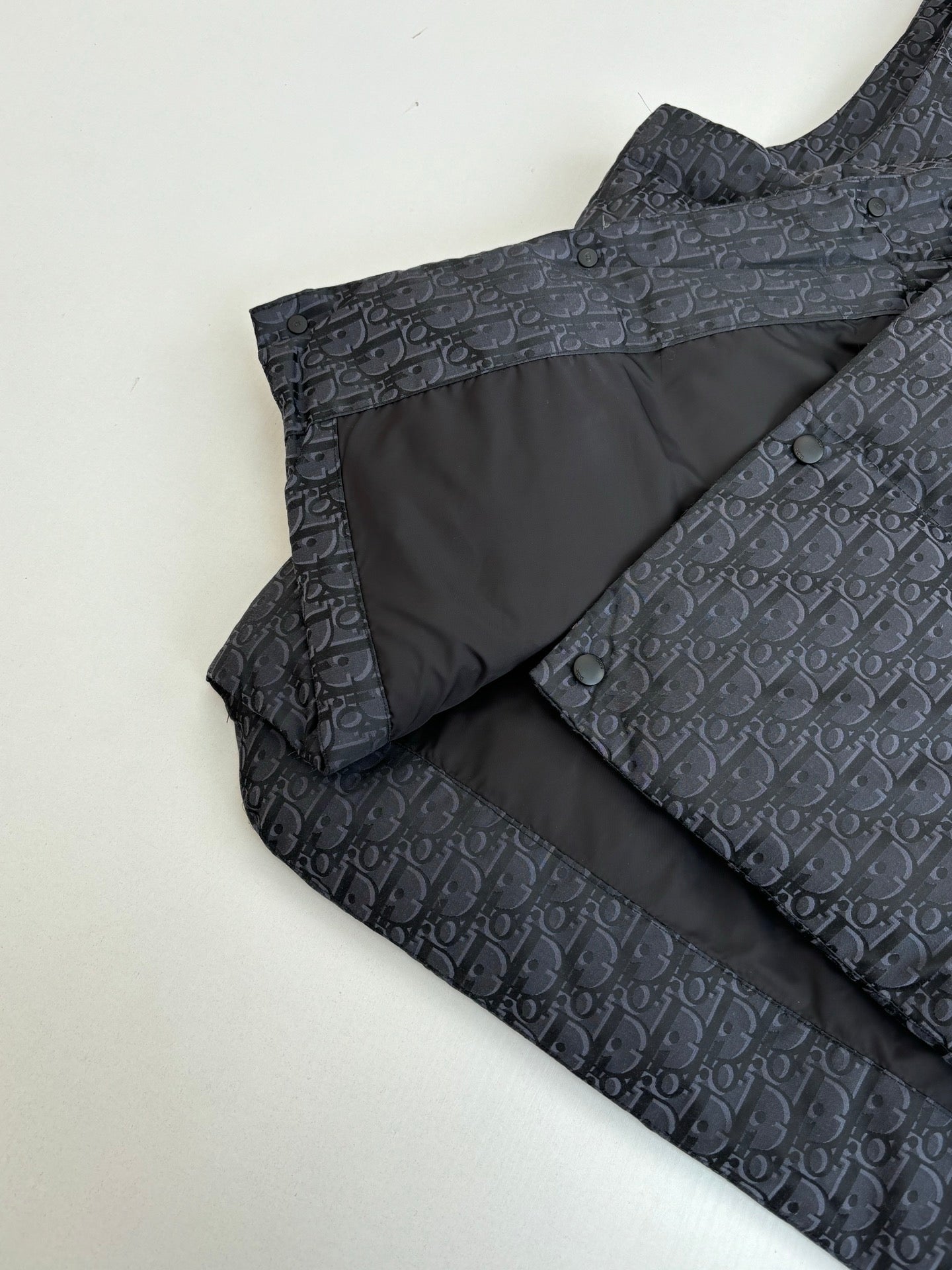 Sleeveless vest interior with dark Dior monogram shell and black lining panel.