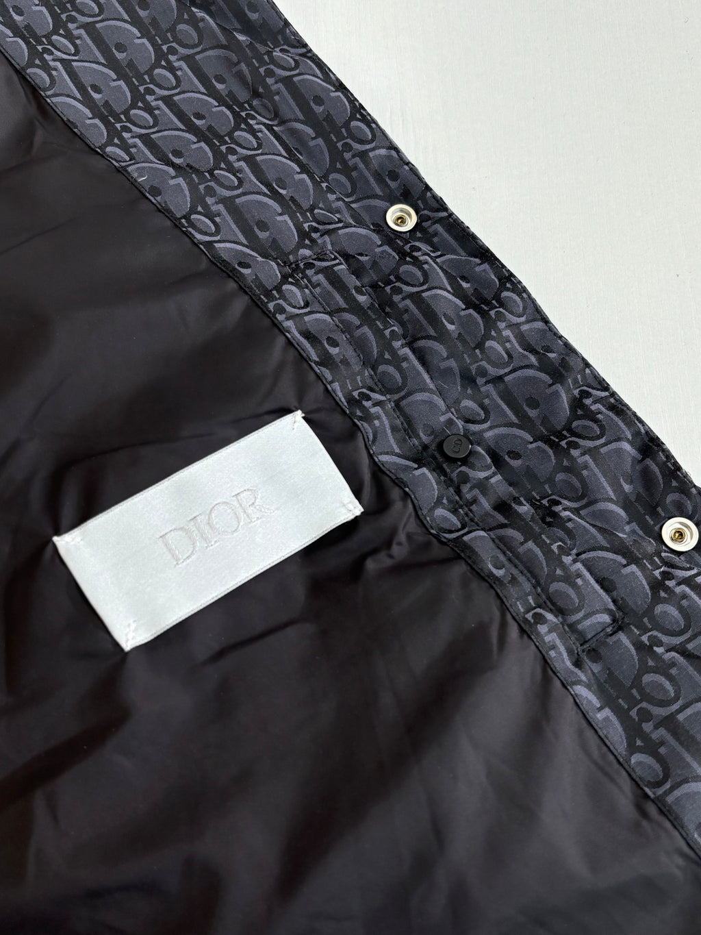 Dark Dior monogram vest with button fastening and white Dior logo patch detail.