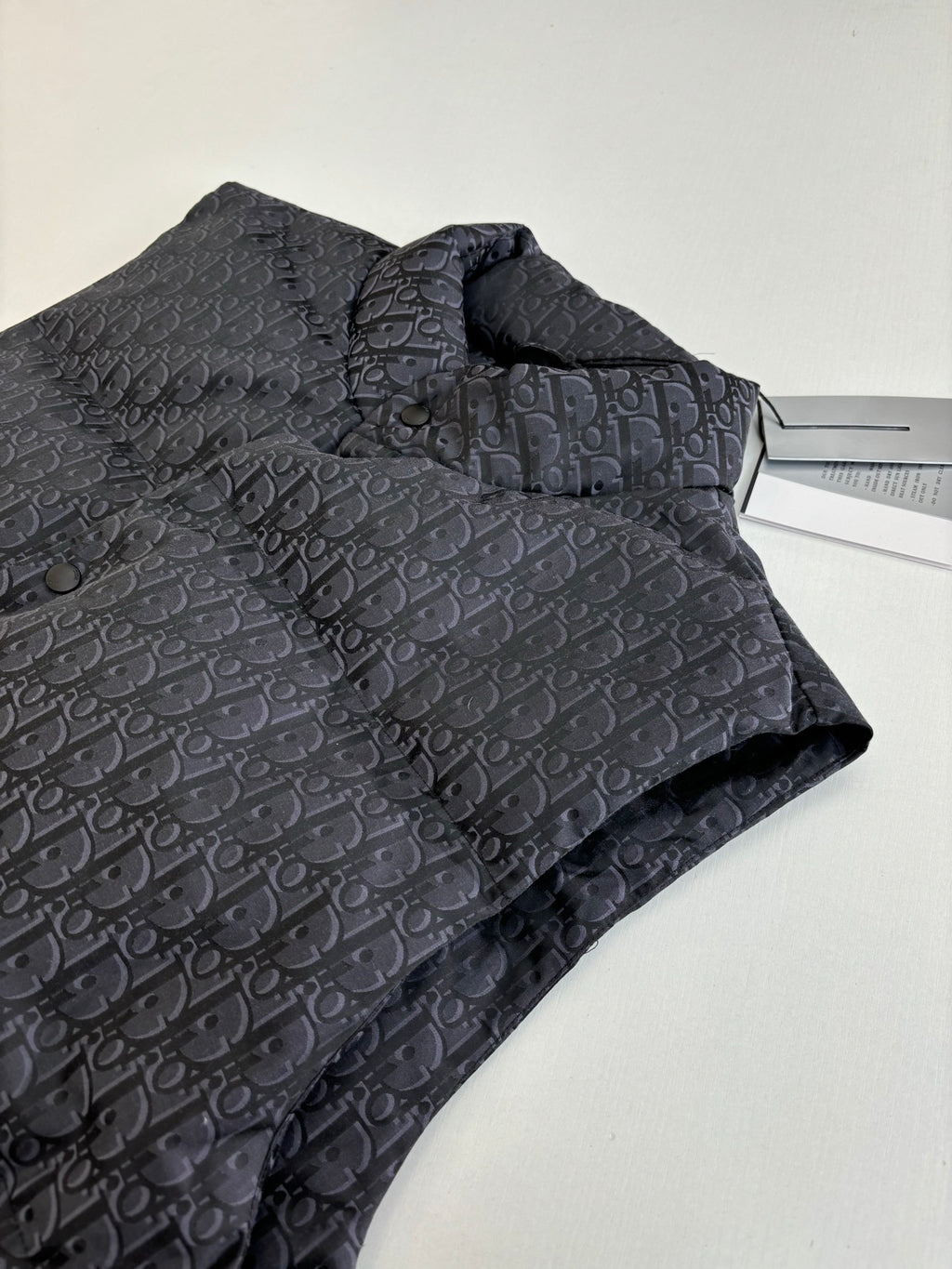 Folded sleeveless quilted vest in dark Dior monogram fabric with stand collar.