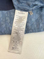 Care label and size tag on blue monogram fabric of a sleeveless vest