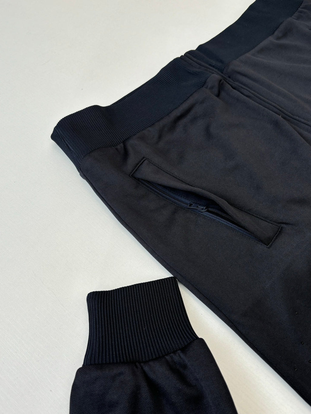 Gucci zip jacket close-up with dark navy drawstring waist and ribbed knit cuffs