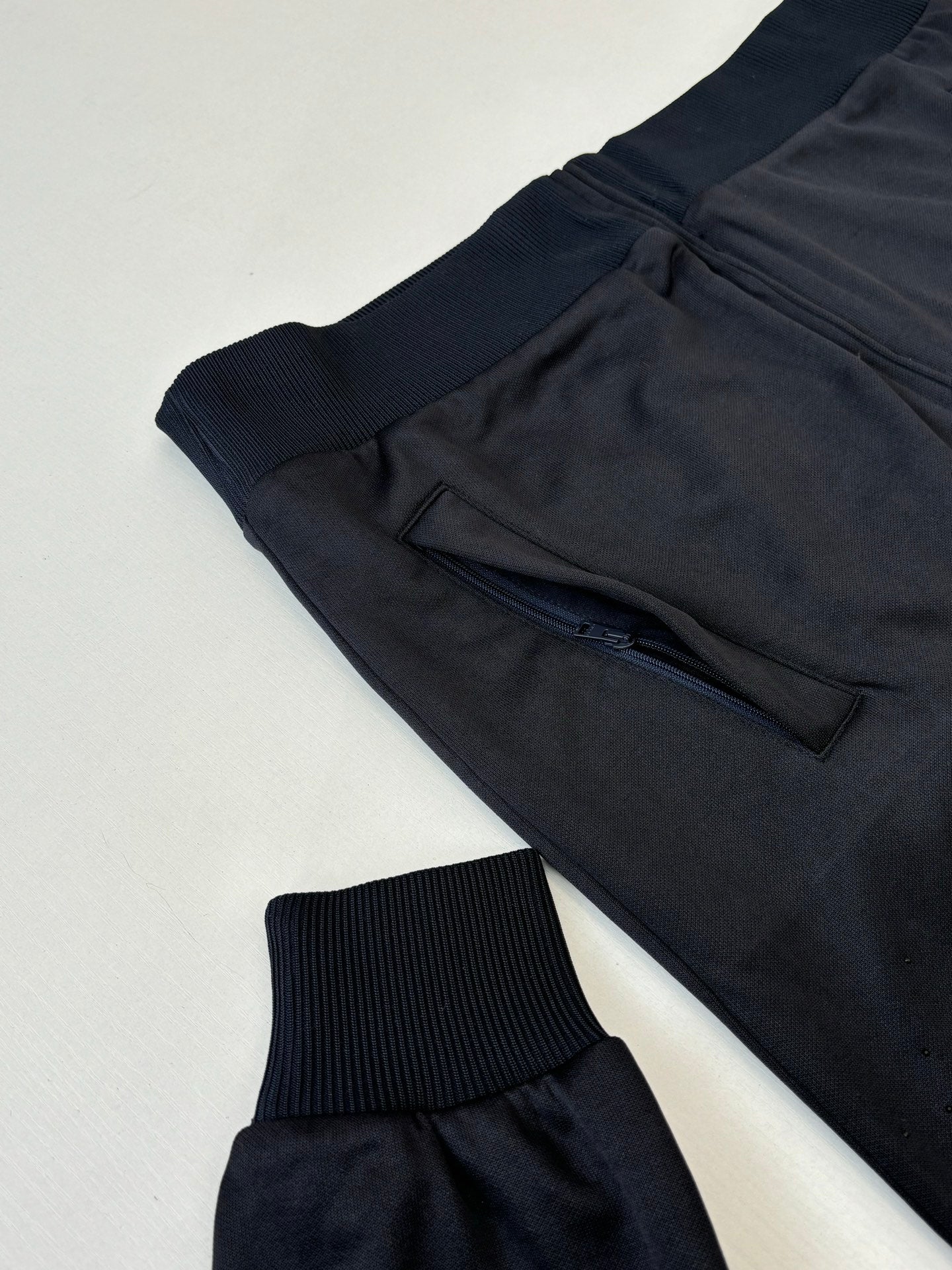 Gucci zip jacket close-up with dark navy drawstring waist and ribbed knit cuffs