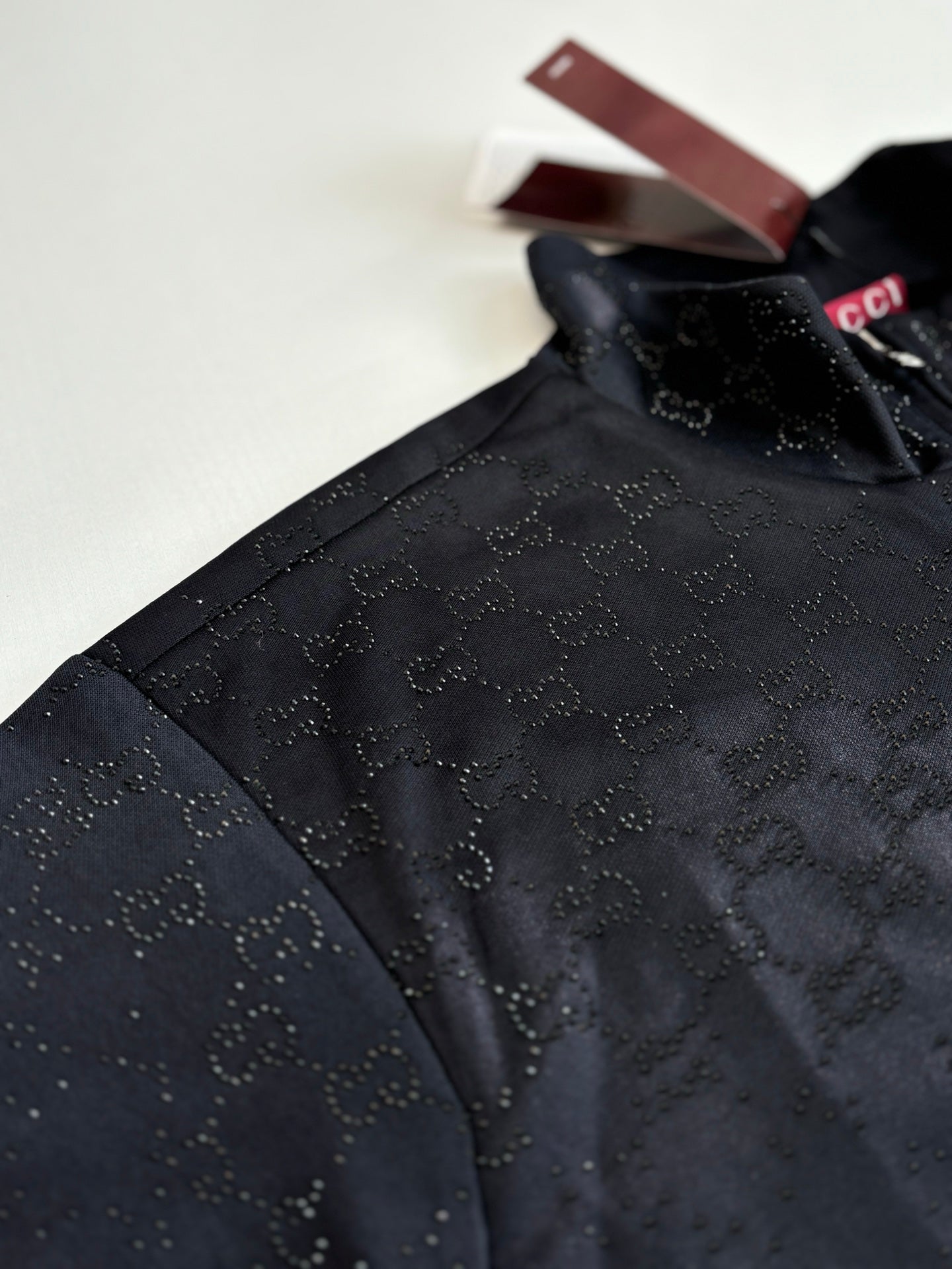 Gucci jacket detail: dark navy monogram pattern on shoulder and sleeve