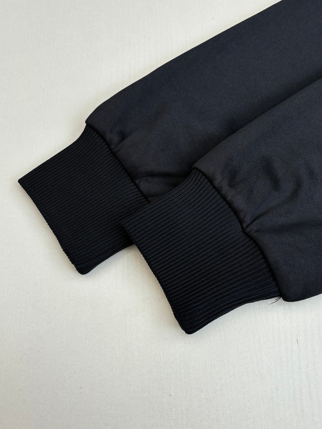 Gucci jacket hem and ribbed cuff cuffs in dark navy, folded close-up