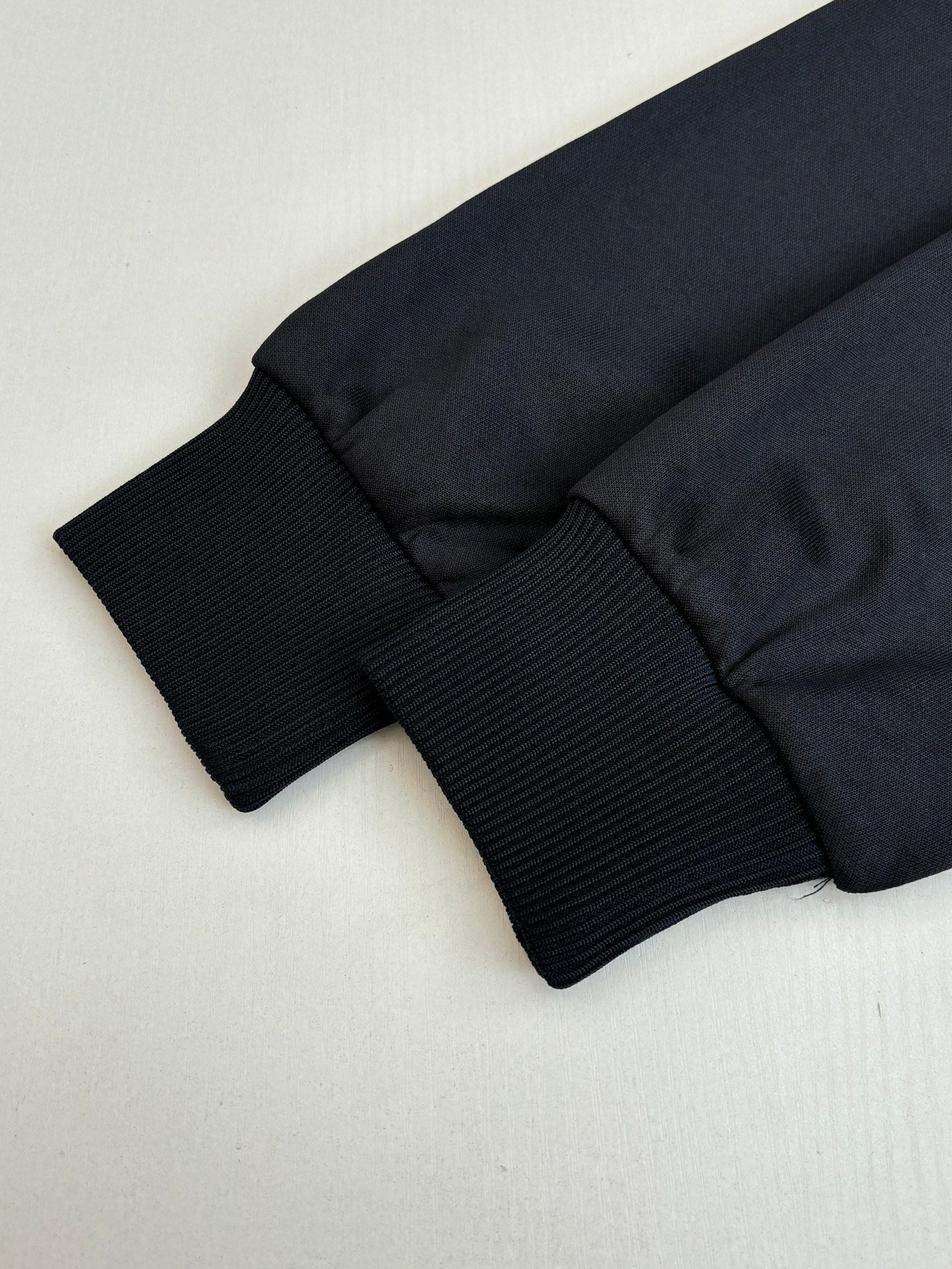 Gucci jacket hem and ribbed cuff cuffs in dark navy, folded close-up