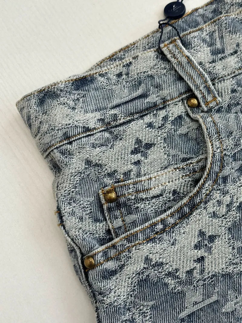 Blue monogram denim shorts close-up: buttoned flap pocket and contrast stitching
