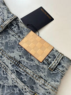 Blue monogram denim shorts close-up with tan check leather card holder