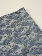Close-up of blue monogram denim shorts side panel with stitched seam