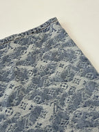 Blue monogram denim shorts fabric close-up with repeating pattern