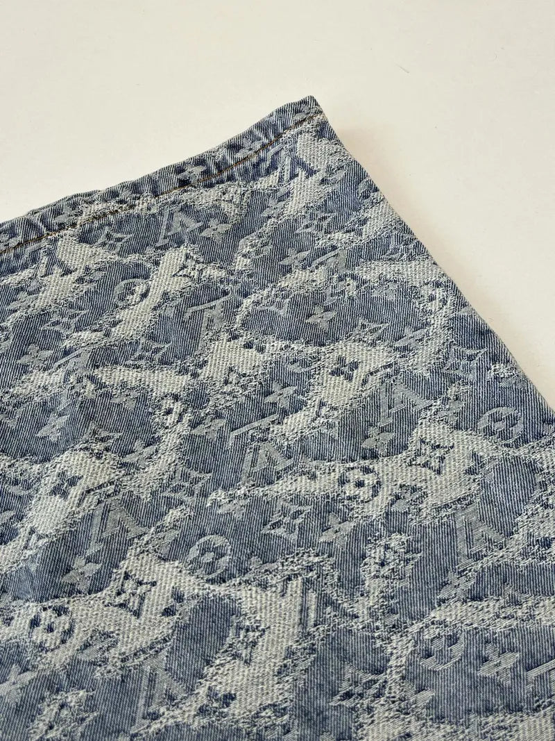 Blue monogram denim shorts fabric close-up with repeating pattern