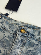 Close-up of blue monogram denim shorts waistband with gold button