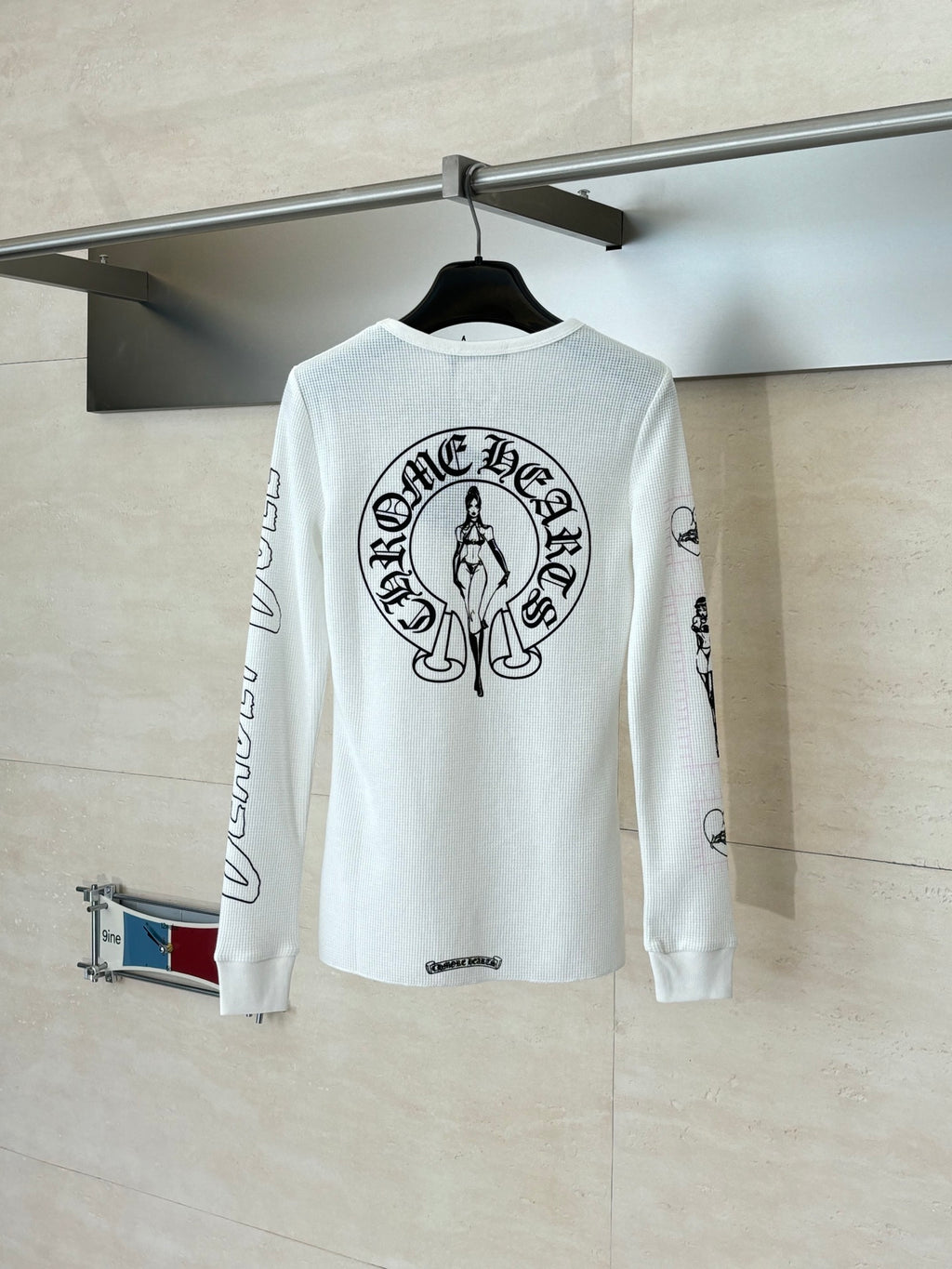 White long-sleeve crewneck shirt with large back crest graphic
